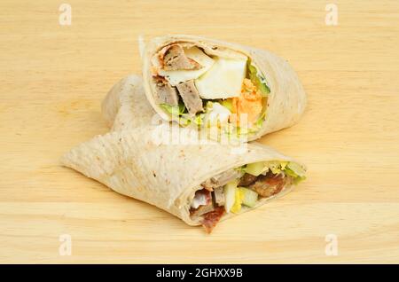 Würstchen, hartgekochtes Ei und Salat werden auf einem Holzbrett verpackt Stockfoto
