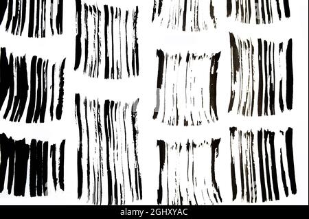Schwarze abstrakte Pinselstriche und Farbspritzer auf Papier. Grunge Kunst Kalligraphie Hintergrund Textur Stockfoto