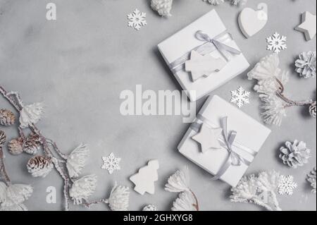 Mockup Weihnachtsrahmen mit Zapfen und Holzspielzeug und Geschenkboxen Grenze über grauen abstrakten Hintergrund, mit Platz für Ihren Text Stockfoto