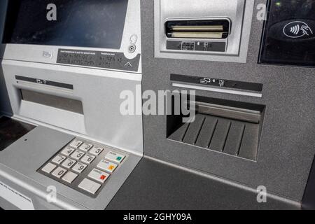 Abgewinkelte Ansicht eines Geldautomaten mit Zahlungspads und eines Scheckeingabeplatzes an einem Außenautomaten außerhalb einer Bank. Stockfoto