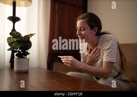 Frau reagiert auf das Ergebnis ihres Covid-19-Selbsttests Stockfoto