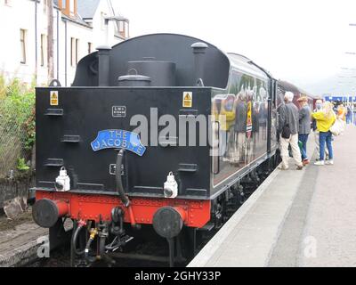 Passagiere auf dem Bahnsteig in Fort William bewundern den Motor des Jacobite-Dampfzuges, bevor sie auf der West Highland Line nach Mallaig fahren. Stockfoto