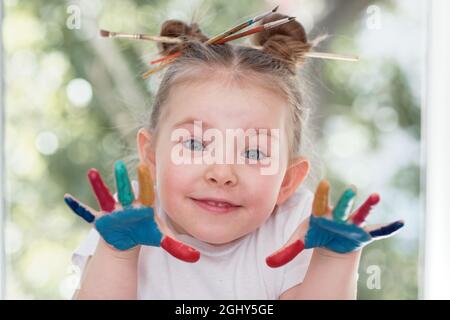 Bildung, Schule, Kunst und Schmerzkonzept - kleines Schülermädchen mit gemalten Händen. Hochwertige Fotos Stockfoto