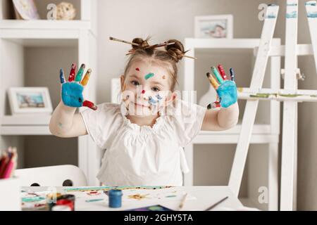 Bildung, Schule, Kunst und Schmerzkonzept - kleines Schülermädchen mit gemalten Händen. Hochwertige Fotos Stockfoto