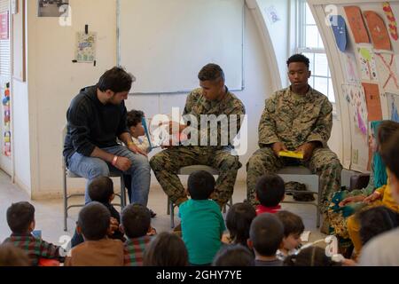 Quantico, Usa. September 2021. US-Marineinfanteristen lasen ein Buch vor afghanischen Kindern, die von Kabul zur Marine Corps Base Quantico am 6. September 2021 in Quantico, Virginia, USA, evakuiert wurden. Quantico stellt den Afghanen vorübergehend Wohnraum zur Verfügung, da sie für die Einwanderung verarbeitet werden. Kredit: LCpl. Eric Huynh/US Marines Photo/Alamy Live News Stockfoto