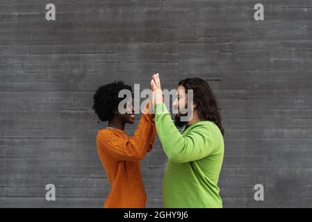 Porträt eines glücklichen, interracial Paares, das sich die Hände hält, während es sich anschaut. Stockfoto