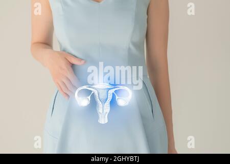 Nicht erkennbare Patientin in blauer Kleidung, in den Händen durch Handzeichen hervorgehobener Uterus. Menschliches Fortpflanzungssystem gibt Konzept aus. Stockfoto