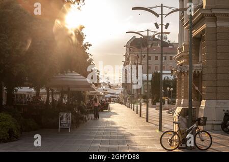 Bild von Rijeka in der Abenddämmerung mit Fußgängern, die auf Terrassen auf Verdijeva ulica sitzen. Rijeka ist eine kroatische Hafenstadt an der Kvarner Bucht in der nördlichen Adria Stockfoto