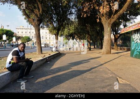 ROM, ITALIEN - 01. Sep 2019: Ein schwarzer Mann sitzt in der Nähe des Bahnhofs Roma Termini in Rom, Italien am Morgen Stockfoto