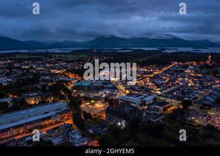 Luftaufnahme der malerischen Touristenstadt Killarney im County Kerry in Irland mit eingeschalteten Lichtern unter einem bewölkten, frühmorgens bewölkten Himmel Stockfoto