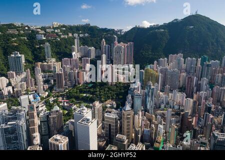 Die Hochhäuser mit Wohnhäusern in den mittleren Etagen und Luxushäusern auf dem Peak über den Geschäftsgebäuden von Central, Hong Kong Island Stockfoto