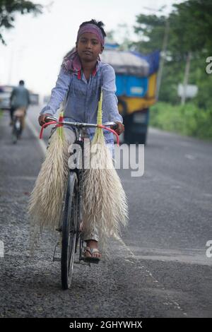 23. September 2020, Flughafen Barisal, Barisal, Bangladesch. Ein Kind trägt Cashew-Blumen auf einem Fahrrad Stockfoto