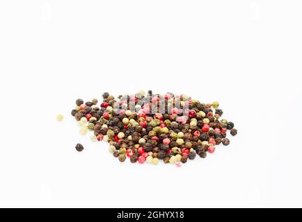 Isolierte Pfefferkörner-Mischung aus schwarzen, weißen, rosa und grünen Pfefferkörnern auf weißem Hintergrund. Stockfoto