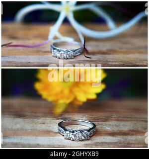 Diamantring aus drei Steinen in Weißgold, platziert auf Holz mit Blumen dahinter, geringer Schärfentiefe Stockfoto