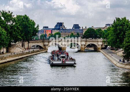 Paris, Frankreich - 27. Mai 2018: Vergnügungsboot, das mit Touristen unter der Brücke segelt. Stockfoto