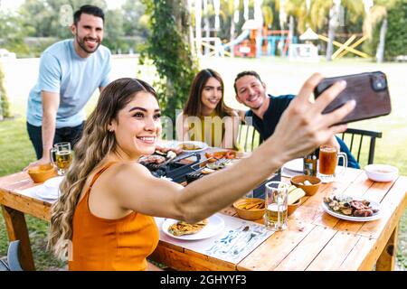 Eine Gruppe lateinamerikanischer Freunde, die ein Selfie machen und mexikanisches Essen auf der Restaurantterrasse in Mexiko, Lateinamerika, essen Stockfoto