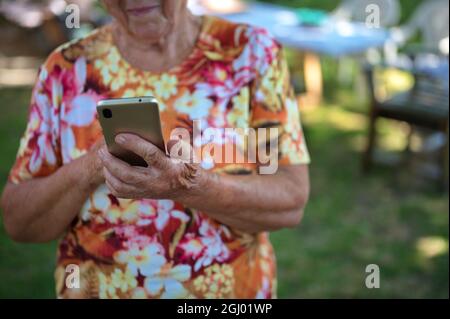 Mittelteil der älteren Frau mit Handy Stockfoto