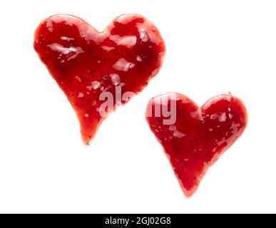 Zwei freihändig gezeichnete Herzen aus roter Beerenkonfitüre auf Weiß mit verschiedenen Größen und Formen, die von Liebe, Liebe und Romantik gedanklich sind Stockfoto