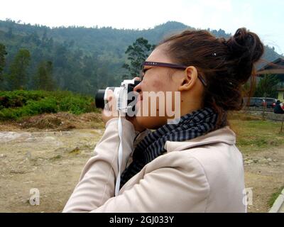 Eine Fotografin fotografiert die Landschaft auf dem dieng-Hochplateau. Stockfoto