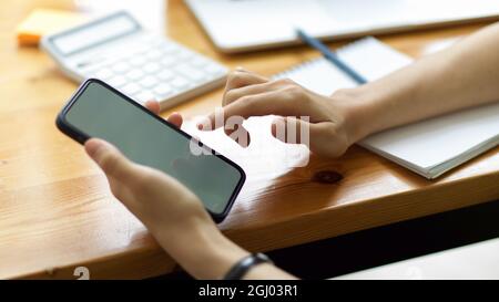 Nahaufnahme, Hände der Frau mit dem Mobiltelefon, Berühren des Bildschirms, Scrollen auf dem Telefon, Herunterladen der mobilen Anwendung, Surfen im Internet Stockfoto