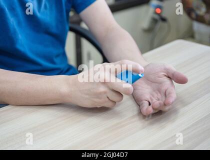 Finger pumpende Alkoholspray auf der Handfläche Stockfoto