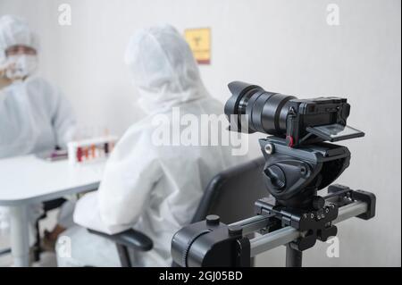 Spiegellose Kamera auf Gleitschiene Filmen Wissenschaftler experimentieren Chemikalien Flüssigkeit im Labor Stockfoto