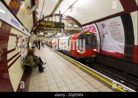 Passagiere, die auf einen Zug der nördlichen Linie in Richtung Süden, die U-Bahn-Station Hampstead, warten. Der Bahnhof Hampstead ist die tiefste Station des Londoner U-Bahnnetzes in 58.5 Metern (192 Fuß) unter dem Erdboden.die Station wurde vom Architekten Leslie Green entworfen und am 22. Juni 1907 eröffnet. Hampstead U-Bahn-Station, Hampstead, London, Großbritannien. 27 August 2011 Stockfoto