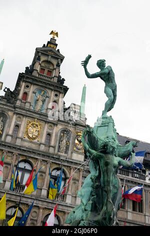Statue von Brabo und der Hand des Riesen mit dem Antwerpener Rathaus in Antwerpen an einem bewölkten Sommertag. Stockfoto