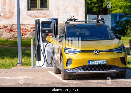 Aluksne, Lettland - 19. Juni 2021: Volkswagen ID.4 ist ein Elektro-Crossover-SUV steht auf dem Parkplatz neben der elektrischen Ladestation Stockfoto