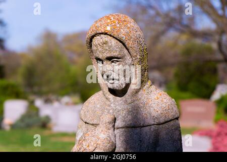 Eine steinerne Statue von Jesus mit einem Vogel auf einem Friedhof, Friedhof. In Arlington, Virginia. Stockfoto