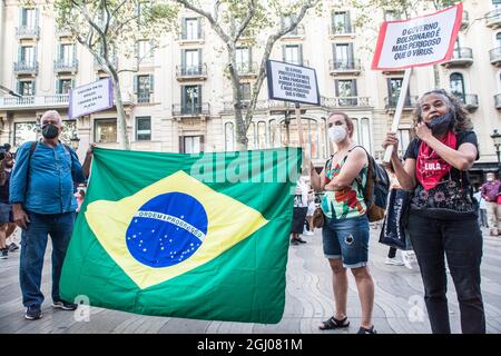 Barcelona, Katalonien, Spanien. September 2021. Die Demonstranten werden mit einer brasilianischen Flagge und einem Transparent gesehen, auf dem steht, dass die Regierung Bolsonaro gefährlicher ist als das Virus.am Tag der Unabhängigkeit Brasiliens, dem 7. September, hat der Präsident von Brasilien, Jair Bolsonaro, Hat seine Anhänger zu Demonstrationen im ganzen Land geladen und schürt Bedrohungen für die Demokratie und einen möglichen Staatsstreich. Verschiedene Gruppen und politische Parteien im Land haben dagegen reagiert und Demonstrationen gegen den Präsidenten aufgerufen, in Barcelona hat eine Gruppe Brasilianer einen Akt gegen den Vorsitzenden durchgeführt Stockfoto