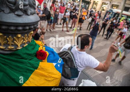 Barcelona, Katalonien, Spanien. September 2021. Der Demonstranten spielt typische brasilianische Musikinstrumente vor einer brasilianischen Flagge mit Rose.am Tag der Unabhängigkeit Brasiliens, dem 7. September, spielte der Präsident Brasiliens, Jair Bolsonaro, Hat seine Anhänger zu Demonstrationen im ganzen Land geladen und schürt Bedrohungen für die Demokratie und einen möglichen Staatsstreich. Verschiedene Gruppen und politische Parteien im Land haben dagegen reagiert und Demonstrationen gegen den Präsidenten aufgerufen, in Barcelona hat eine Gruppe von Brasilianern einen Akt gegen den Präsidenten auf den Ramblas ( Stockfoto