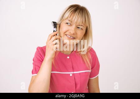 Attraktive blonde Arzt zeigt Ausrüstung für die Untersuchung Ohr. Moderne medizinische Geräte. Otolaryngologe. Ärztliche Untersuchung. Neueste Technologie Stockfoto