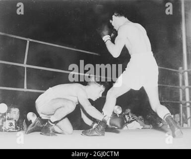 Pascuel Perez ( rechts ), der Weltmeister im Fliegengewicht, bringt den spanischen Young Martin in der dritten Runde ihres 15-Runden-Weltmeisterschaftskampfes in Buenos Aires, Argentinien, am 12. Dezember 1957 ins Rennen Stockfoto