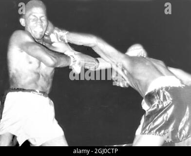 Weltmeister Don Jordan ( links ) nimmt Herausforderer Virgil Atkins bei ihrem Weltgewichtskampf in St. Louis, USA, eine harte Linke ins Gesicht. Jordan gewann den Boxmeistertitel am 25. April 1959 Stockfoto