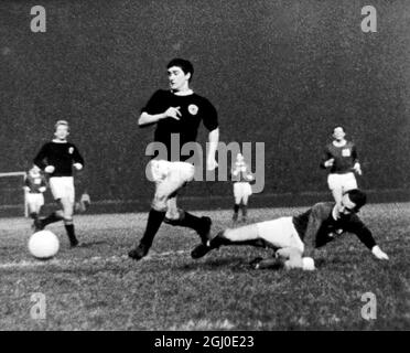 Schottland gegen Irland John Parke aus Irland (vor Ort) kann den schottischen Jim Baxter während des Spiels in Glasgow, Schottland, nicht stoppen. Im Hintergrund steht Denis Law of Scotland. November 1964. Stockfoto