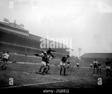 Manchester-Utd-Torhüter Gregg fliegt über die Köpfe zweier Spieler, eines Verteidigers von Manchester United und des anderen angreifenden Spurs-Spielers Dunmore, während des Spiels der Division One zwischen Tottenham Hotspur und Manchester Utd in der White Hart Lane. Februar 1959. Stockfoto