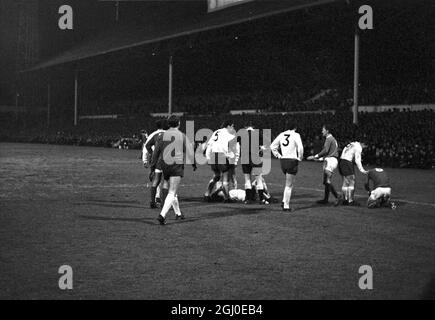 Tottenham Hotspur gegen Manchester United zwei Spieler lagen auf dem Spielfeld in der White Hart Lane, nachdem sie in der dritten Runde des FA Cup erneut aufflammen. Dave Mackay (No.6) zeigt auf Manchester United, innen-rechts Brian Kidd, wobei er seinen Kopf schmerzte, nachdem er sich mit Tottenham rechts hinten Kinnear (am Boden links) zusammengedrückt hatte, was dazu geführt hatte, dass die beiden Männer abgeschickt wurden. Spieler, die den Spurs-Spieler umgeben, sind (von links) Alan Gilzean, George Best, Alan Mullery, Mike England, Pat Jennings, Linker Flügelspieler Beal und Cyril Knowles. Spurs gewann das Spiel 1-0 nach zusätzlicher Zeit. Januar 196 Stockfoto