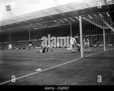 1963 FA Cup Finale Manchester United V Leicester City Center Stürmer David Herd aus Manchester United (zweiter links) freut sich über das dritte Tor für sein Team. Auf dem Boden steht Leicester City Torwart Gordon Banks und (zweite rechts) ist Dennis Law, der seine Hände winkt. Dritte rechts mit der Rückseite zur Kamera ist Leicester City Centre Half I.King. Manchester United besiegte Leicester City 3-1 und gewann den FA Cup. Mai 1963. Stockfoto