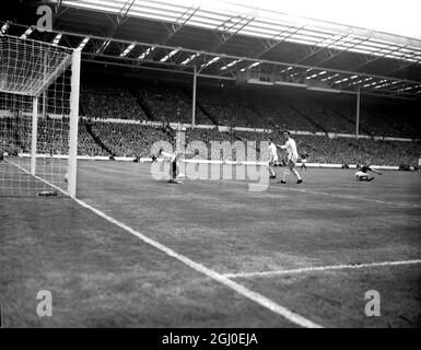 1963 FA Cup Finale Manchester United V Leicester City. Dennis Law, die linke Innenverteidigerin von Manchester United (ganz rechts, am Boden) erzielt das erste Tor für sein Team, während zwei nicht identifizierte Verteidiger von Leicester City Torhüter Gordon Banks vergeblich beim Tauchen zusehen. Manchester United besiegte Leicester City 3-1 und gewann den FA Cup. Mai 1963. Stockfoto