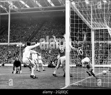 1963 FA Cup Final Manchester United gegen Leicester City das zweite Tor von Manchester United wird von dem Mittelstürmer David Herd (9) erzielt, wobei Dennis Law, United's Inside Left (10) seine Arme vor Freude hochwirft, während ein niedergebeugt Leicester-Torwart Gordon Banks auf den Knien liegt (links). Mai 1963. Stockfoto