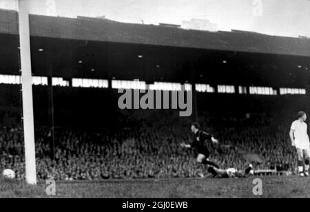 Der Mailänder Mittelstürmer Juan Schiaffino stürzt über den gefallenen Manchester United Torwart Harry Gregg, als der Ball ins Netz geht und das erste Tor für Mailand im Halbfinale des Manchester United gegen den Milan European Cup in Old Trafford anpeilt. Mai 1958. Stockfoto