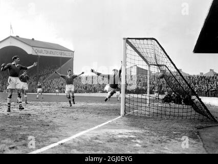 Charlton gegen Manchester United das zweite Tor von Manchester United wird von dem Mittelvorderen Tommy Taylor (nicht im Bild) mit einem Kopfball während des Spiels der Football League Division One gegen Charlton Athletic im Valley erzielt. In einem vergeblichen Versuch, den Ball zu retten, springt Charlton-Torhüter William Duff, während Bill Whelan (Mitte) von Manchester United freudig die Arme hebt. Februar 1957 Stockfoto