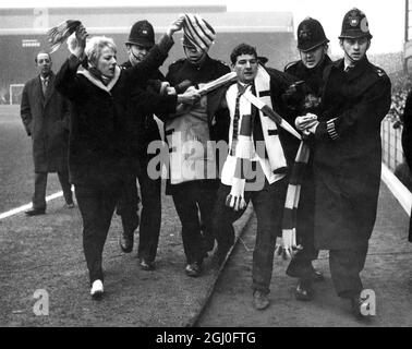 FA Cup 5. Runde Arsenal gegen die Polizei von Liverpool ziehen einen Zuschauer nach einem Vorfall vor dem Start des Spiels in Highbury weg. Februar 1964. Stockfoto