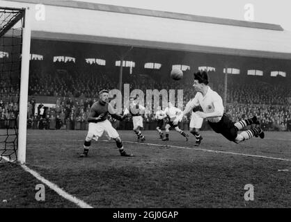 Fulham gegen Rotherham United von links nach links macht Johnny Haynes von Fulham einen fliegenden Sprung, um den Ball in Richtung Rotherham-Tor zu führen. Bolton ist der Rotherham-Torwart. März 1955 Stockfoto