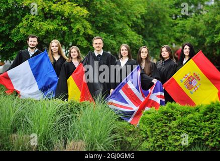 Eine Gruppe von Studenten der Fakultät für Fremdsprachen, die in Gewändern studieren, halten die Flaggen Großbritanniens, Frankreichs, Spaniens und Deutschlands in den Händen. Stockfoto