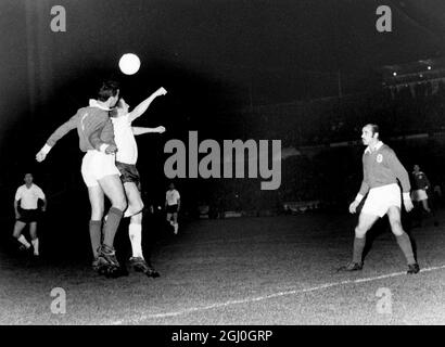 1962 EM-Halbfinale 1. Etappe Benfica gegen Tottenham Hotspur Ein Duell unter dem Flutlicht zwischen Spurs' Jones (weißes Hemd) und Benfica's Angelo, während sie beide während des Spiels in Lissabon um den Ball springen. März 1962 Stockfoto