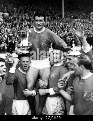 25. April 1963: Das FA-Pokalfinale im Wembley-Stadion. Manchester United (3) gegen Leicester City (1). Foto zeigt: Noel Cantwell, United's Kapitän, wird von Teamkollegen geleitet und hält die FA-Trophäe. Bobby Charlton ist im Bild ganz rechts. 25. Mai 1963: Das FA-Pokalfinale im Wembley-Stadion. Manchester United (3) gegen Leicester City (1). Foto zeigt: Die Gefühle der Pokalsieger werden hier von (l-r) Pat Crerand, Albert Quixall und David Herd ausgedrückt, die zwei Tore von United erzielten. : das FA-Pokalfinale im Wembley-Stadion. Manchester United (3) gegen Leicester City (1). Foto zeigt: Manche Stockfoto