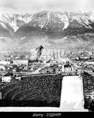 Olympische Winterspiele 1964 - Innsbruck, Österreich von 80,000 Zuschauern beobachtet ein Teilnehmer - einer von 52 aus 480 Nationen - fliegt nach dem Start von einer m hohen Plattform durch die Luft, Während der 80m-Schanze in Innsbruck - dem letzten Event der neunten Olympischen Winterspiele. Die Teilnehmer starten mit einer Geschwindigkeit von etwa 67 km/h, um etwa drei Sekunden lang durch die Luft zu segeln - bis zu einer Geschwindigkeit von über 60 km/h - und landen schließlich bis zu 313 Fuß von der Stelle entfernt, an der sie den Kontakt zum Boden verloren hatten. - 10. Februar 1964 - ©TopFoto Stockfoto