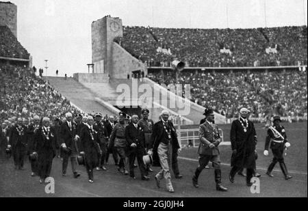 1936 Olympia, Berlin - Adolf Hitler, der Führer und Mäzen, mit einer Eskorte zum Weltsport im Stadion. (Adolf Hitler, der Führer und Schirmherr, mit dem Führer des Weltsportes im Stadion) ©TopFoto Stockfoto